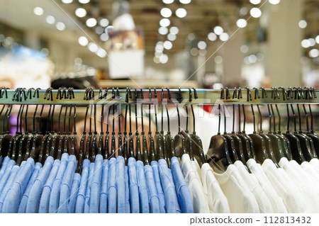 Clothes on hangers in a retail shop. Fashion and shopping concept Clothes on hangers in a retail shop. Fashion and shopping concept 112813432