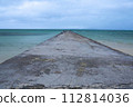 Boardwalk to the horizon with turquoise water and blue sky with clouds. 112814036