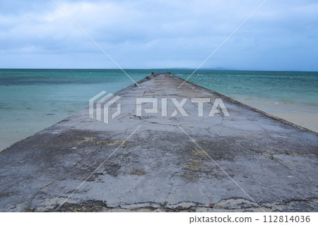 Boardwalk to the horizon with turquoise water and blue sky with clouds. Boardwalk to the horizon with turquoise water and blue sky with clouds. 112814036
