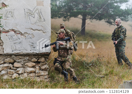 In a high stakes mission, a specialized military unit executes a tactical operation to secure a dangerous house where terrorists are believed to be hiding, showcasing precision and coordinated 112814129