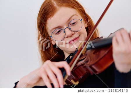 Stunning Redhead Musician Poses with Violin in Captivating Portrait 112814143