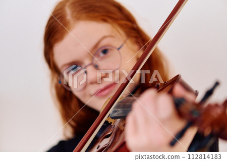 Stunning Redhead Musician Poses with Violin in Captivating Portrait Stunning Redhead Musician Poses with Violin in Captivating Portrait 112814183