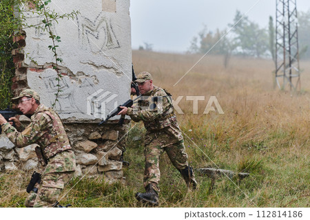 In a high stakes mission, a specialized military unit executes a tactical operation to secure a dangerous house where terrorists are believed to be hiding, showcasing precision and coordinated In a high stakes mission, a specialized military unit executes a tactical operation to secure a dangerous house where terrorists are believed to be hiding, showcasing precision and coordinated 112814186