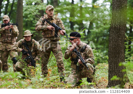 A disciplined and specialized military unit, donned in camouflage, strategically patrolling and maintaining control in a high-stakes environment, showcasing their precision, unity, and readiness for A disciplined and specialized military unit, donned in camouflage, strategically patrolling and maintaining control in a high-stakes environment, showcasing their precision, unity, and readiness for 112814409