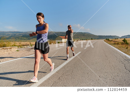 Energized by the beauty of nature, a couple powers through their morning run, their bodies and spirits invigorated. Energized by the beauty of nature, a couple powers through their morning run, their bodies and spirits invigorated. 112814459