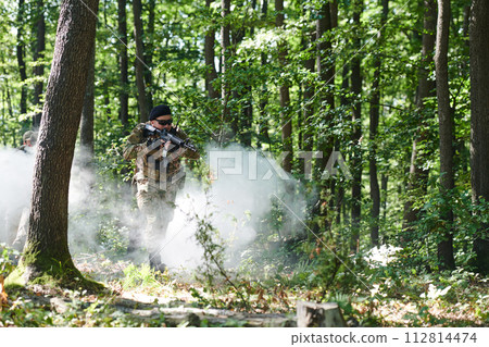 A specialized military antiterrorist unit conducts a covert operation in dense, hazardous woodland, demonstrating precision, discipline, and strategic readiness A specialized military antiterrorist unit conducts a covert operation in dense, hazardous woodland, demonstrating precision, discipline, and strategic readiness 112814474