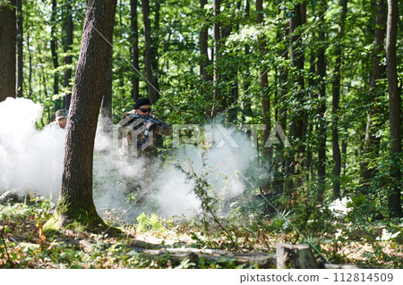 A specialized military antiterrorist unit conducts a covert operation in dense, hazardous woodland, demonstrating precision, discipline, and strategic readiness 112814509