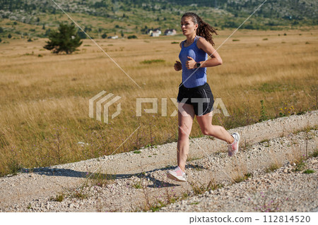 Solo Stride: Determined Athlete Woman Embarks on Fitness Journey for Marathon Preparation. 112814520