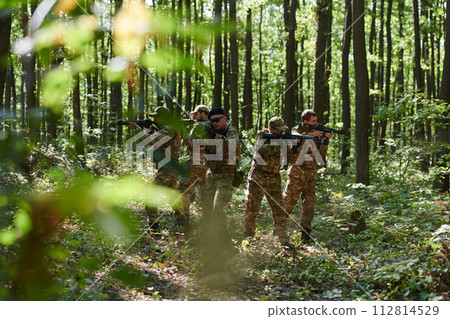 A specialized military antiterrorist unit conducts a covert operation in dense, hazardous woodland, demonstrating precision, discipline, and strategic readiness A specialized military antiterrorist unit conducts a covert operation in dense, hazardous woodland, demonstrating precision, discipline, and strategic readiness 112814529