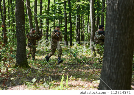 A specialized military antiterrorist unit conducts a covert operation in dense, hazardous woodland, demonstrating precision, discipline, and strategic readiness A specialized military antiterrorist unit conducts a covert operation in dense, hazardous woodland, demonstrating precision, discipline, and strategic readiness 112814571