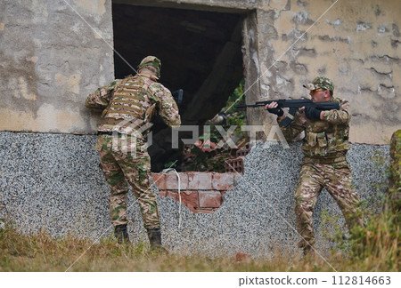 In a high stakes mission, a specialized military unit executes a tactical operation to secure a dangerous house where terrorists are believed to be hiding, showcasing precision and coordinated In a high stakes mission, a specialized military unit executes a tactical operation to secure a dangerous house where terrorists are believed to be hiding, showcasing precision and coordinated 112814663