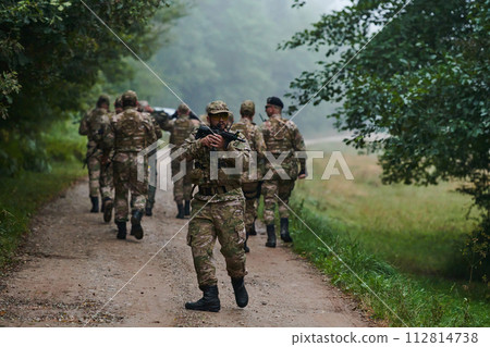 A group of elite soldiers leads captives through a military camp, showcasing a tense atmosphere of detention and security operations A group of elite soldiers leads captives through a military camp, showcasing a tense atmosphere of detention and security operations 112814738