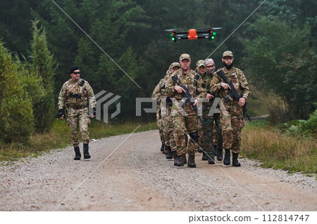 An elite military unit, led by a major, confidently parades through dense forest, showcasing precision, discipline, and readiness for high-risk operations 112814747