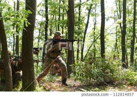 A specialized military antiterrorist unit conducts a covert operation in dense, hazardous woodland, demonstrating precision, discipline, and strategic readiness A specialized military antiterrorist unit conducts a covert operation in dense, hazardous woodland, demonstrating precision, discipline, and strategic readiness 112814857