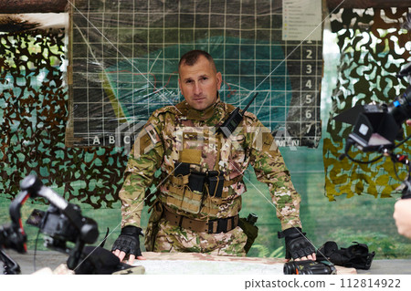 The esteemed leader of an elite military unit, strategic brilliance unfolds as he meticulously devises tactical plans for the upcoming military operation, surrounded by cutting-edge technology and a The esteemed leader of an elite military unit, strategic brilliance unfolds as he meticulously devises tactical plans for the upcoming military operation, surrounded by cutting-edge technology and a 112814922