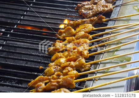 Asian cuisine, Malaysia chicken satay cooking on a hot charcoal grill. Asian cuisine, Malaysia chicken satay cooking on a hot charcoal grill. 112815178