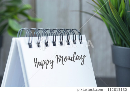Happy monday text on white calendar with green potted plant background. 112815180