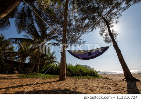 Amazing beach in Goa with hammock (or Karntaka or Kerala) and sand beach for recreation and Indian ocean Amazing beach in Goa with hammock (or Karntaka or Kerala) and sand beach for recreation and Indian ocean 112816724