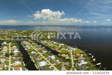 Aerial view of residential suburbs with private homes located on gulf coast near wildlife wetlands with green vegetation on sea shore. Living close to nature concept Aerial view of residential suburbs with private homes located on gulf coast near wildlife wetlands with green vegetation on sea shore. Living close to nature concept 112818334