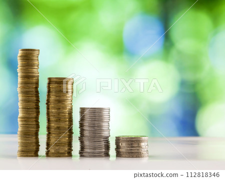 Growing coins stacks with green and blue sparkling bokeh background. Financial growth, saving money, business finance wealth and success concept. 112818346