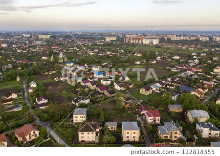 Aerial landscape of small town or village with rows of residential homes and green trees. Aerial landscape of small town or village with rows of residential homes and green trees. 112818355