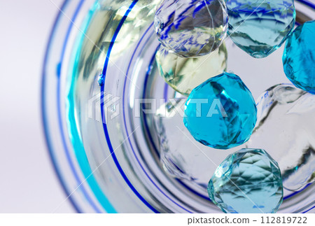 Cool glass bowl and glass beads, close-up 112819722