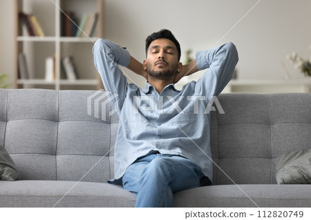 Indian man relaxing at home fell asleep leaned on couch 112820749