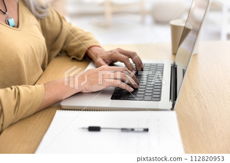 Hands of senior woman in casual typing on laptop keyboard Hands of senior woman in casual typing on laptop keyboard 112820953