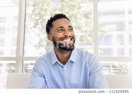Cheerful attractive young Black man looking away Cheerful attractive young Black man looking away 112820995
