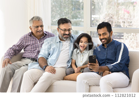 Cheerful Indian great grandpa, grandad, father and kid using phone Cheerful Indian great grandpa, grandad, father and kid using phone 112821012