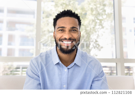 Cheerful African freelance business man talking on video conference call Cheerful African freelance business man talking on video conference call 112821108