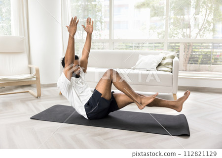 Concentrated athletic Black man training strong body at home 112821129