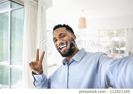 Happy joyful African American guy showing victory winner fingers sign 112821160