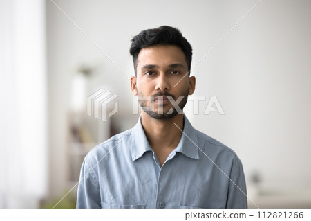 Serious Indian guy in casual blue shirt posing for camera 112821266