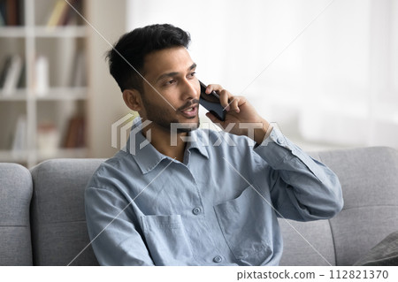 Indian man talking to customer services by phone call Indian man talking to customer services by phone call 112821370