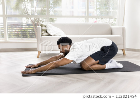 Happy young African American man doing yoga at home Happy young African American man doing yoga at home 112821454