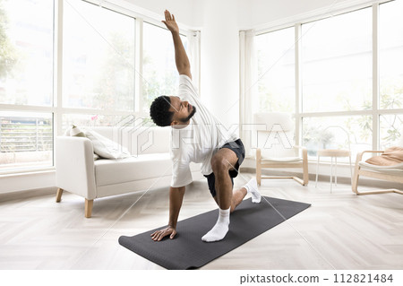 Serious young Black man doing morning exercises at home 112821484