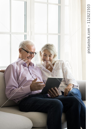 Mature woman and older father using modern tablet device Mature woman and older father using modern tablet device 112821503