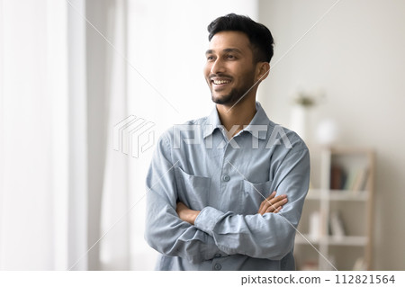 Indian man standing with arms crossed smiling looking away Indian man standing with arms crossed smiling looking away 112821564