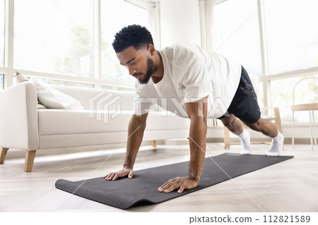 Focused athletic strong African man doing pushups, morning exercises 112821589