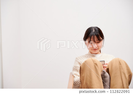 一位女士在家中操作智慧型手機 112822091
