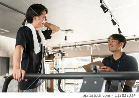 在健身房、教練、教練和物理治療師接受個人訓練的男子 112822334