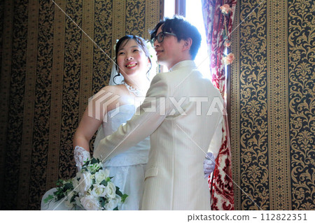 Indoor photo wedding of the bride in a wedding dress and the groom in a tuxedo 112822351