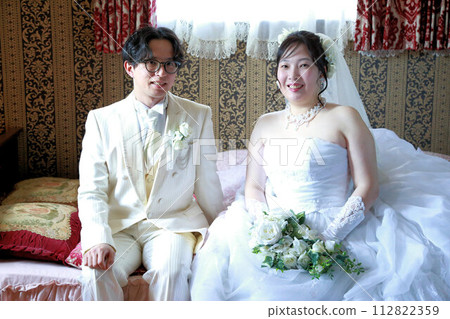 Indoor photo wedding of the bride in a wedding dress and the groom in a tuxedo Indoor photo wedding of the bride in a wedding dress and the groom in a tuxedo 112822359