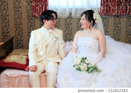 Indoor photo wedding of the bride in a wedding dress and the groom in a tuxedo Indoor photo wedding of the bride in a wedding dress and the groom in a tuxedo 112822362