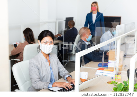 Businesswoman in protective mask working in open plan office 112822747