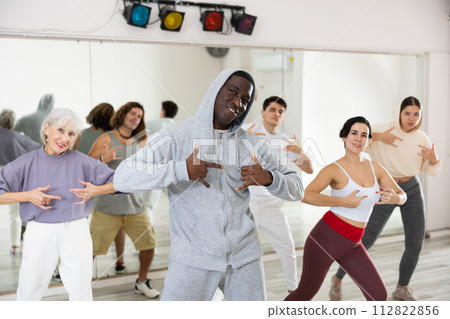 African American man practicing hip-hop movements during group class African American man practicing hip-hop movements during group class 112822856