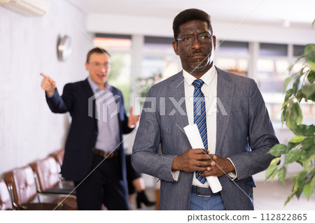 Upset adult man with documents standing in reception 112822865