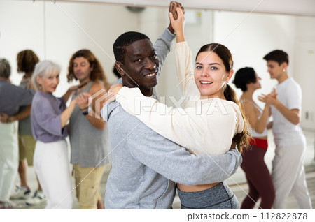 Positive couple of dancers learns a slow foxtrot Positive couple of dancers learns a slow foxtrot 112822878