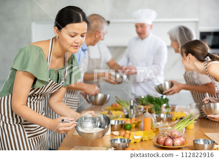 Young Asian woman mixing sauce in bowl at group culinary class 112822916